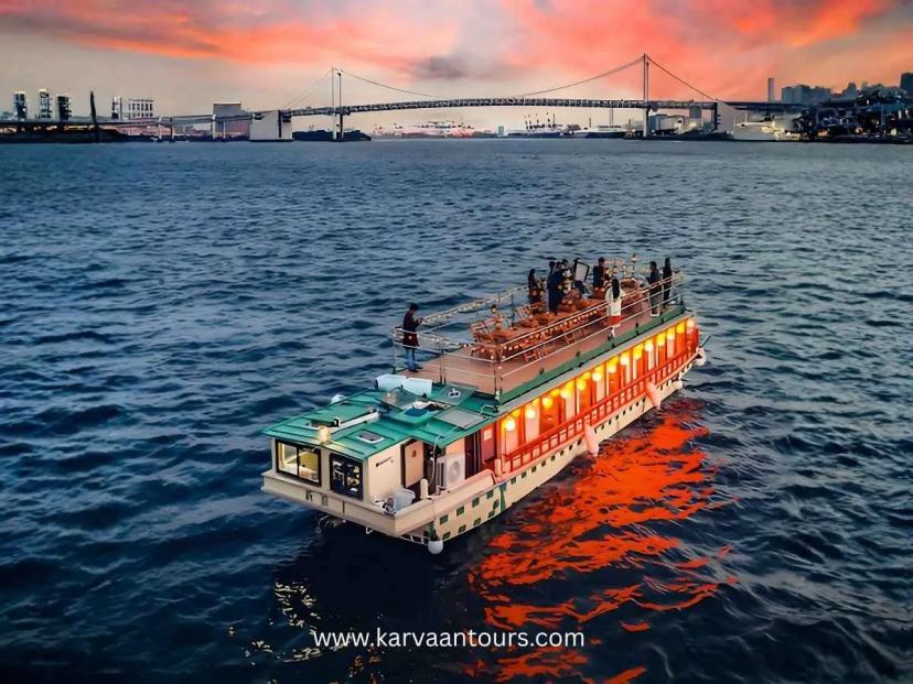 Dinner cruise boat sailing in Tokyo Bay at sunset with Rainbow Bridge in Odaiba Tokyo