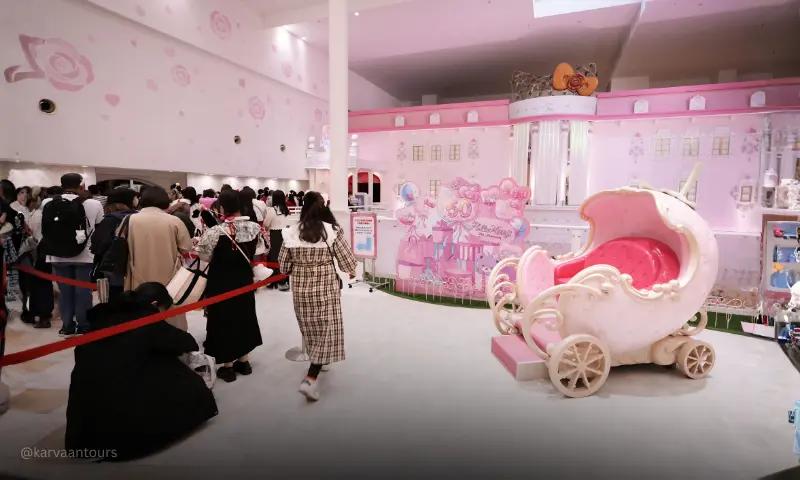Lady Kitty House attraction featuring pink princess carriage and visitors inside Sanrio Puroland Tokyo