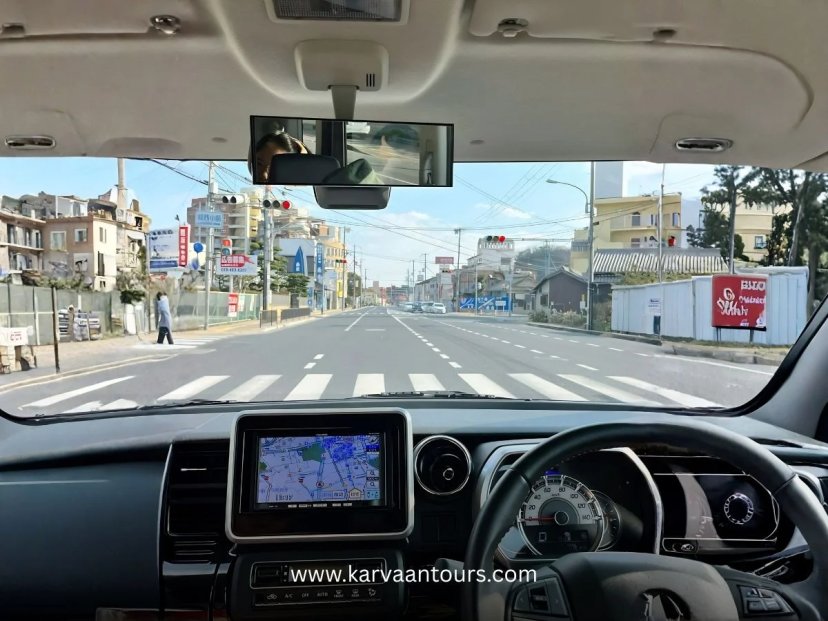 Dashboard view of a car driving on a Japanese city street