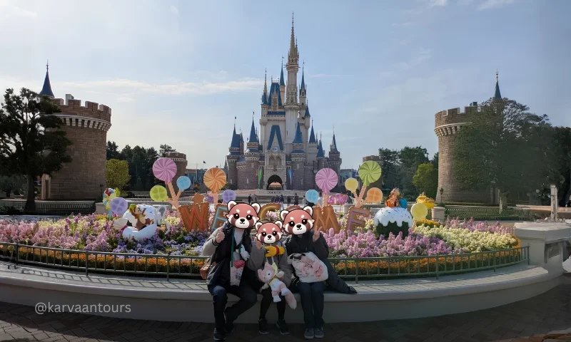 Family posing in front of Cinderella Castle at Tokyo Disneyland