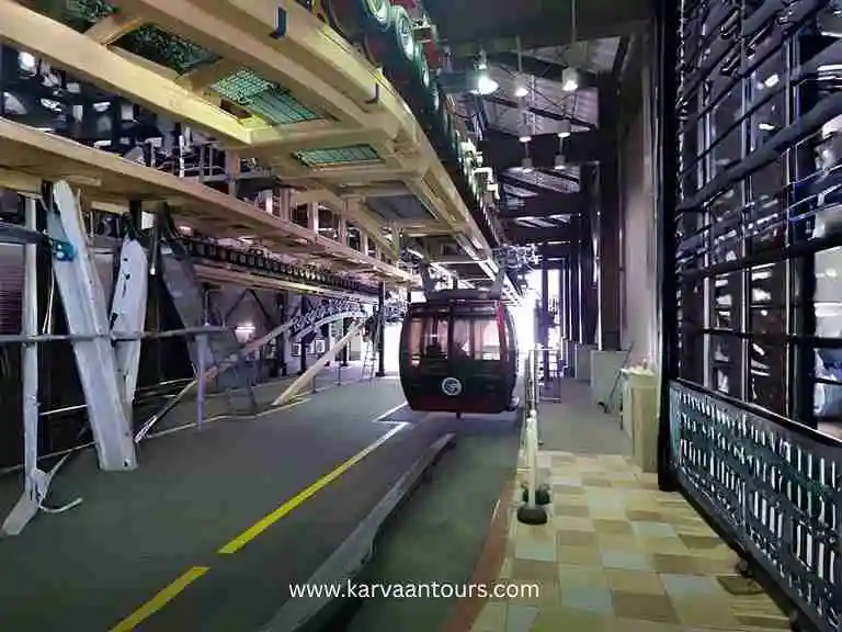 The interior boarding platform of a Hakone Ropeway station, showing the orderly row of gondolas and the mechanical structure of the cable car system.