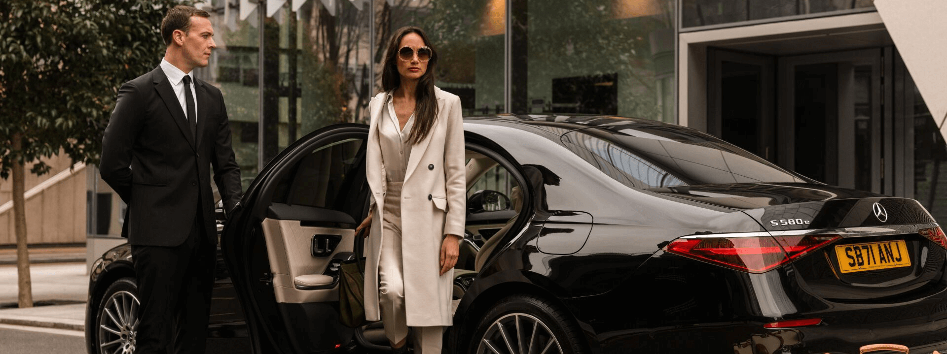 Professional chauffeur opening the rear door of a private car