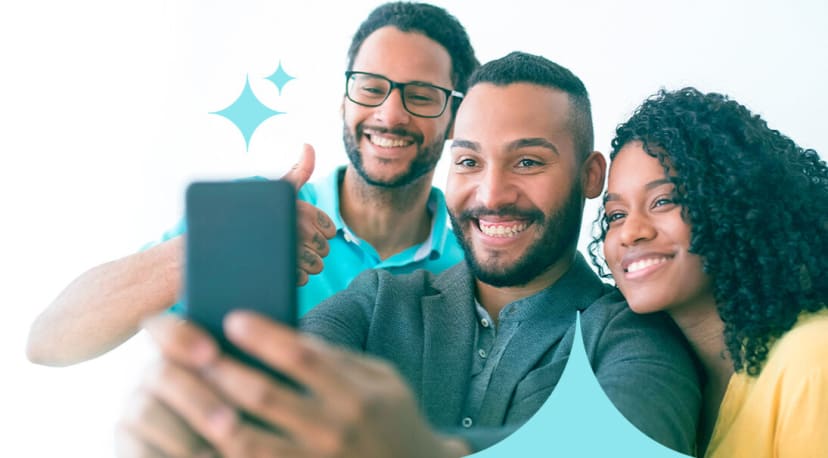 Three colleagues smiling together in a group selfie