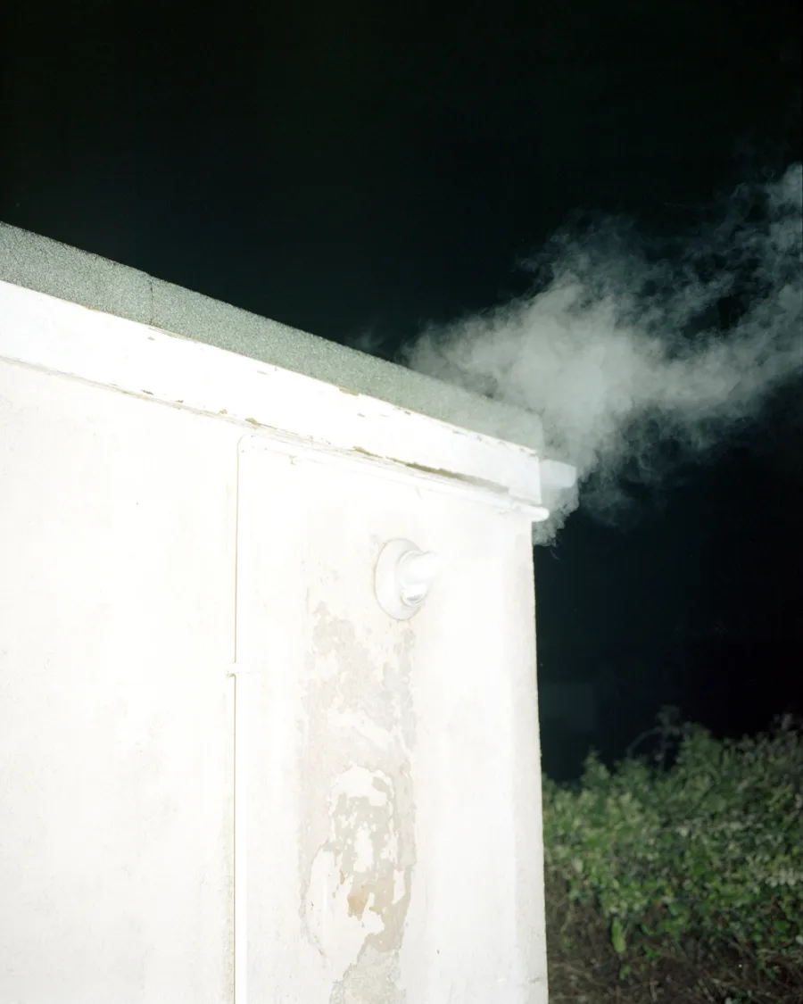 An image of the side of a house with steam coming out of the flu