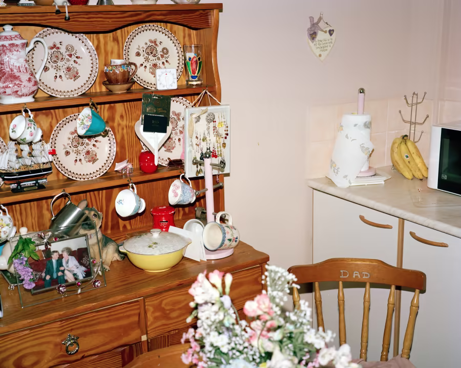 A flash photography image of a welsh dresser full of china plates and cups