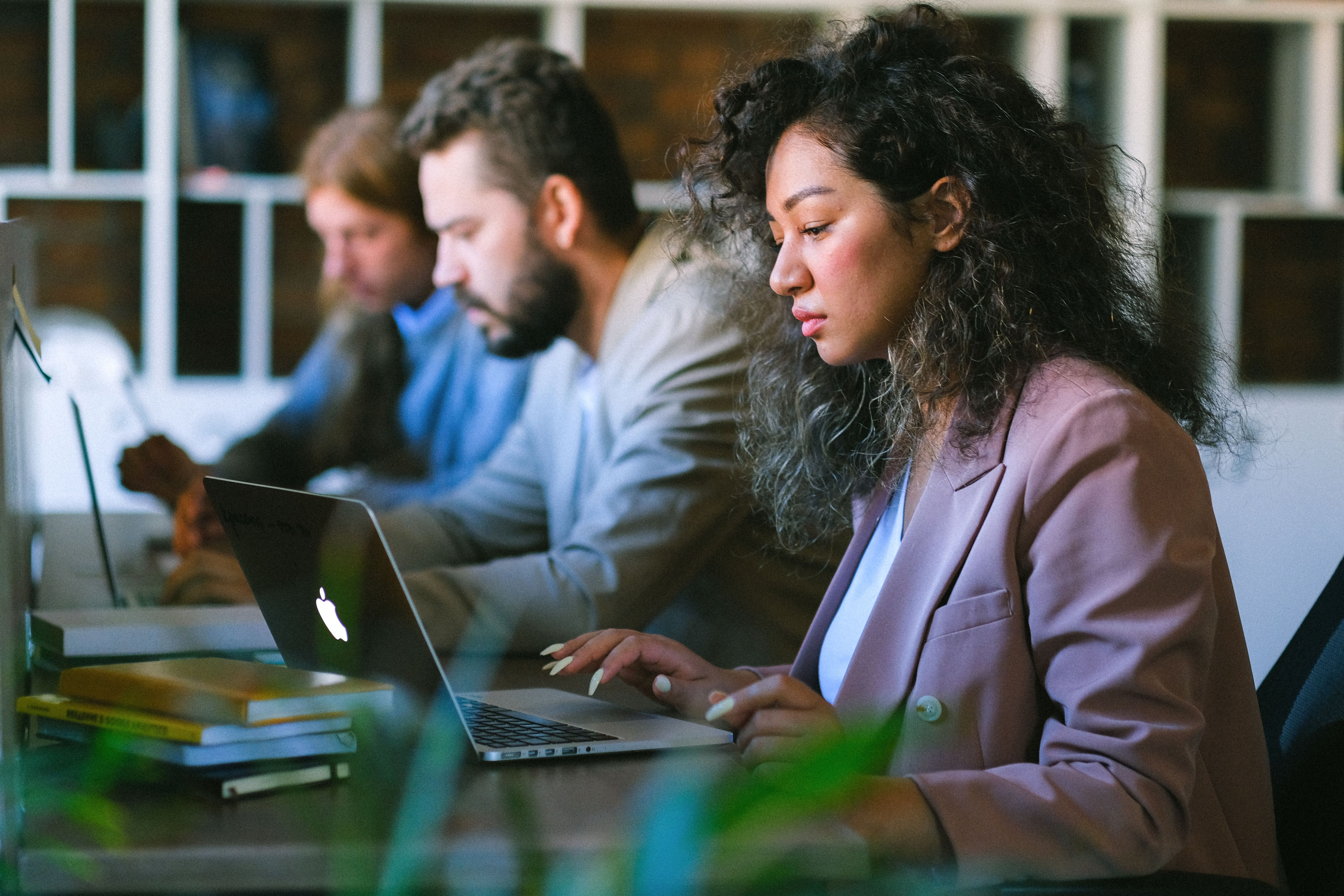 Employees working on computers in an office environment, illustrating the importance of limiting administrator access to protect Northern Kentucky businesses from cybersecurity risks.