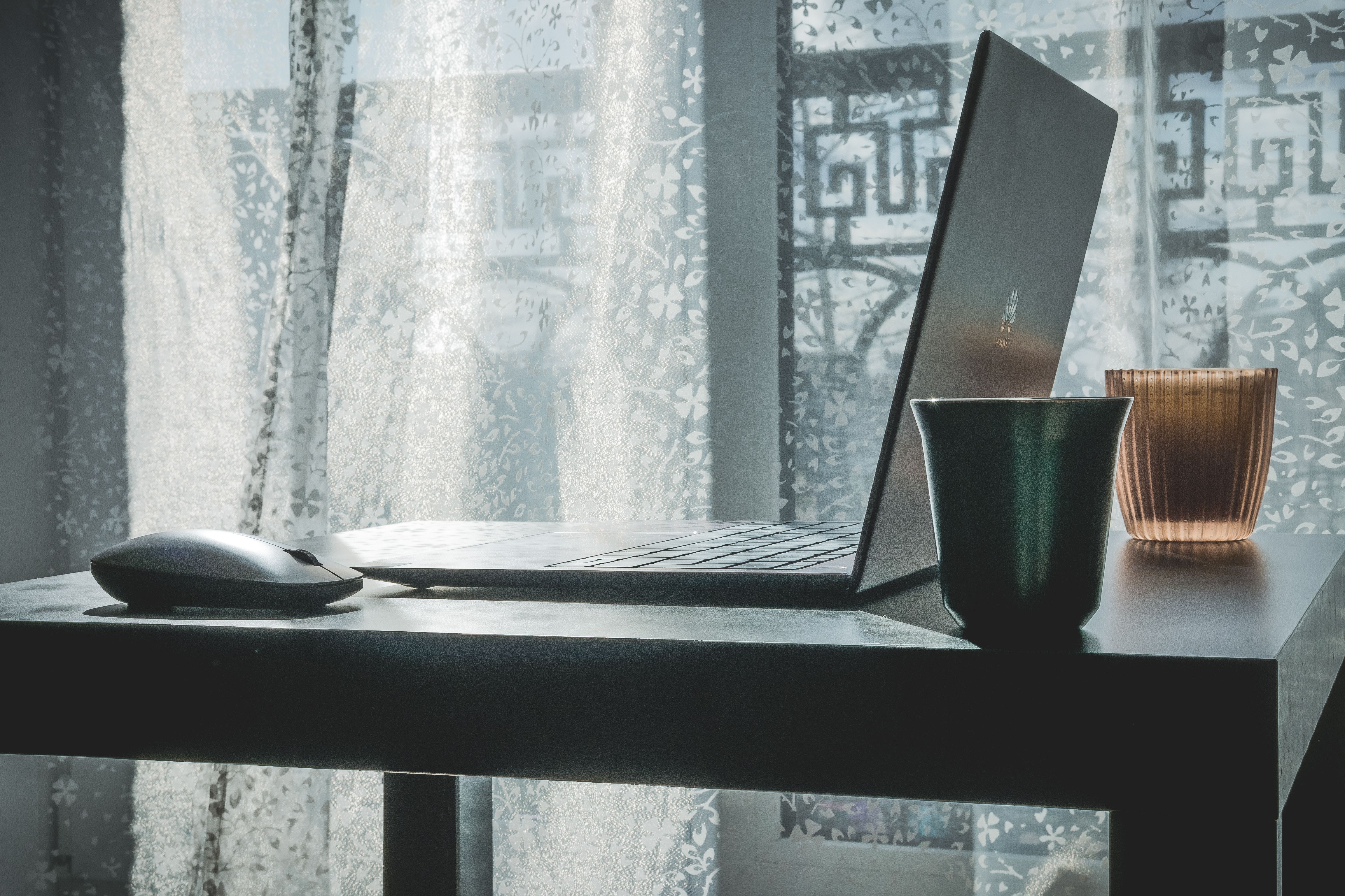 Open laptop and wireless mouse on a desk, representing everyday office computer use and business technology.
