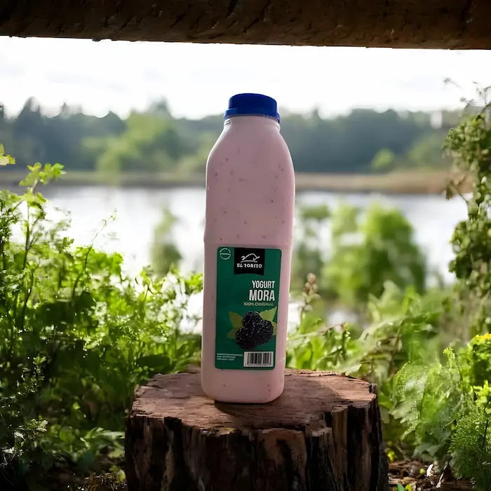 Yogurt de Mora encima de un tronco de madera con un lago de fondo y hojas verdes