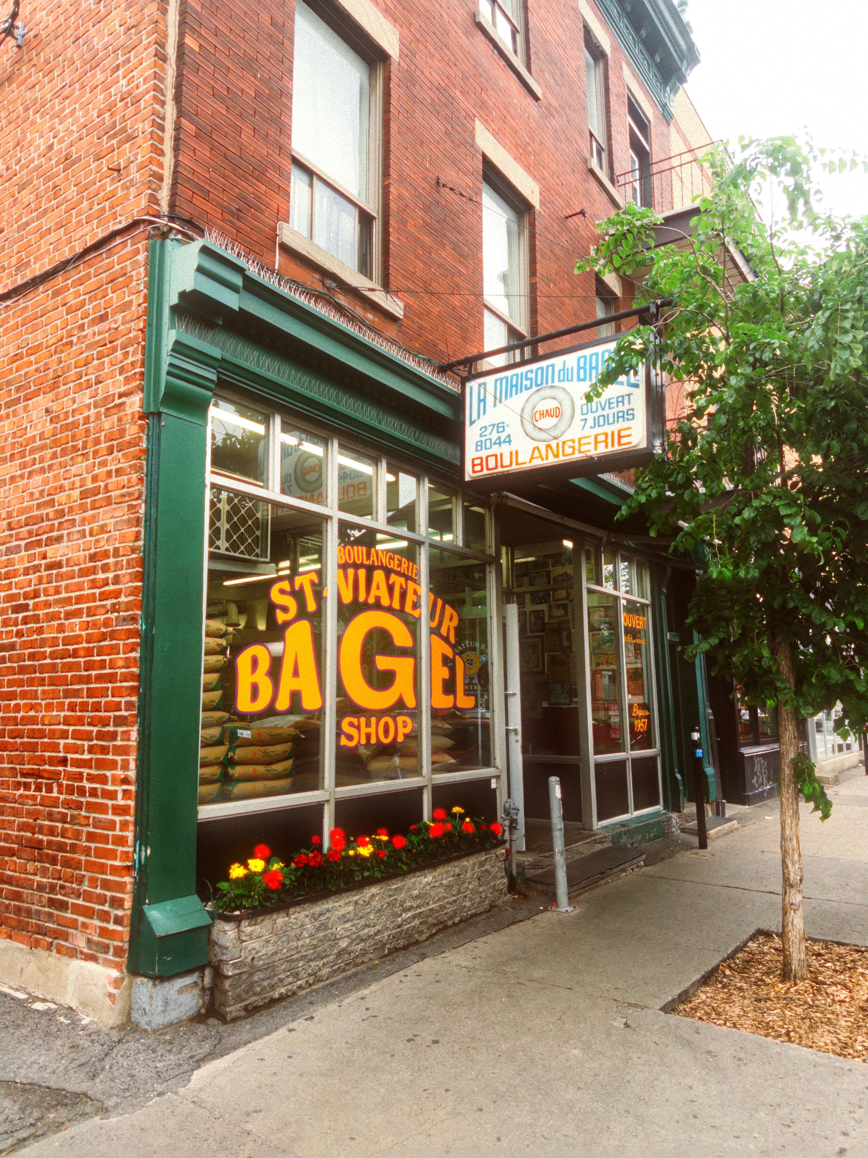 The exterior of the flagship St. Viateur Bagel Shop location. Bags of flour are seen stacked high in the window.