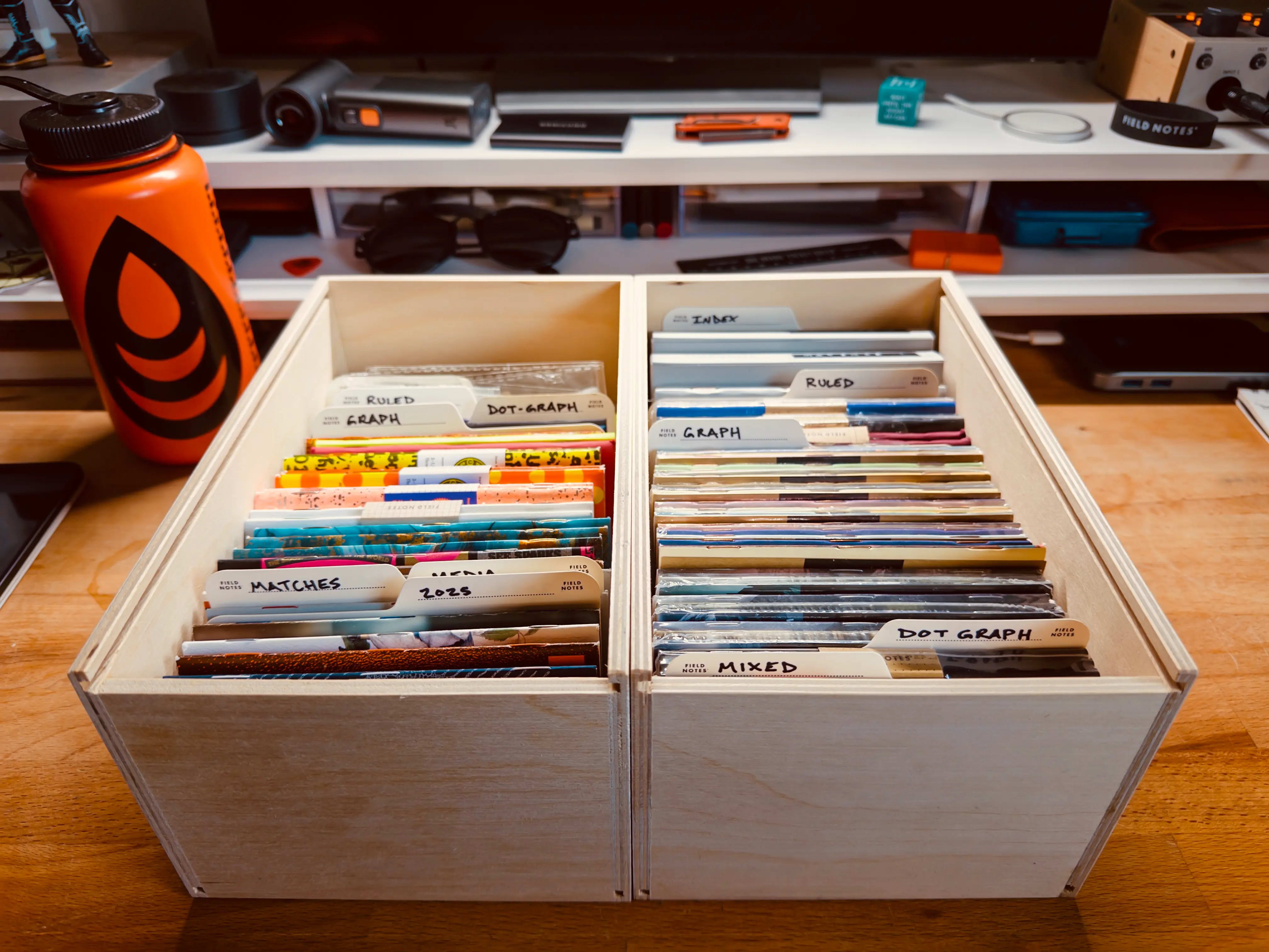Two wooden crates filled with various Field Notes notebooks.