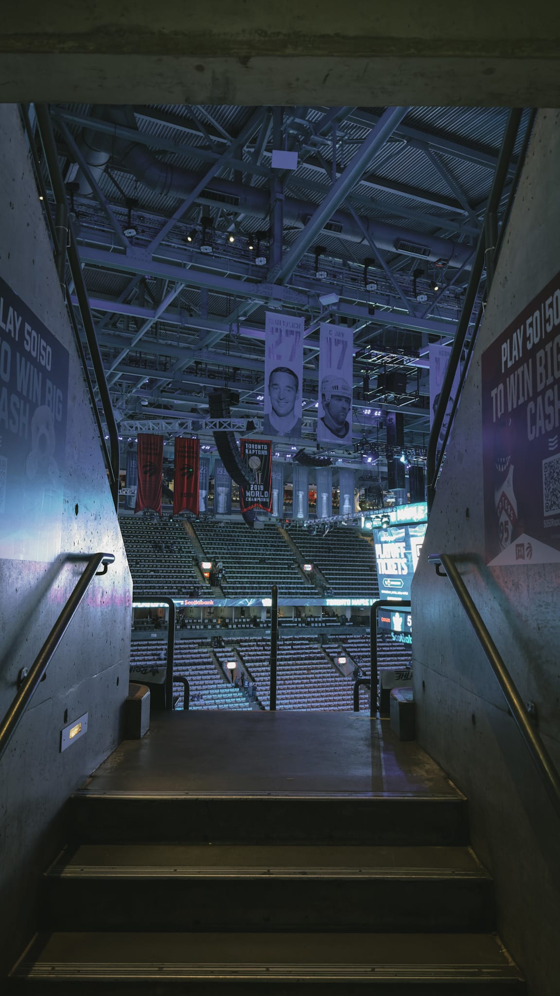 A photo I took of the tunnel leading to our seats at Scotiabank Arena before the Leafs playoff game against the Ottawa Senators on April 22, 2025. The tunnel is dimly lit, with the championship banners hanging from the rafters visible in the background, framed by the tunnel walls.
