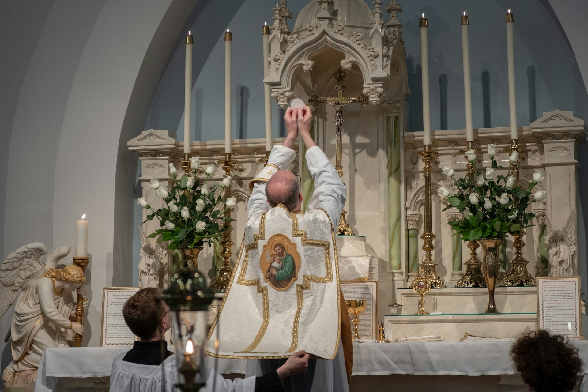 A catholic priest during the consecration at mass (Photo by Shalon Carson - Unsplash)