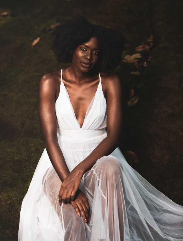 Black woman sitting in white dress