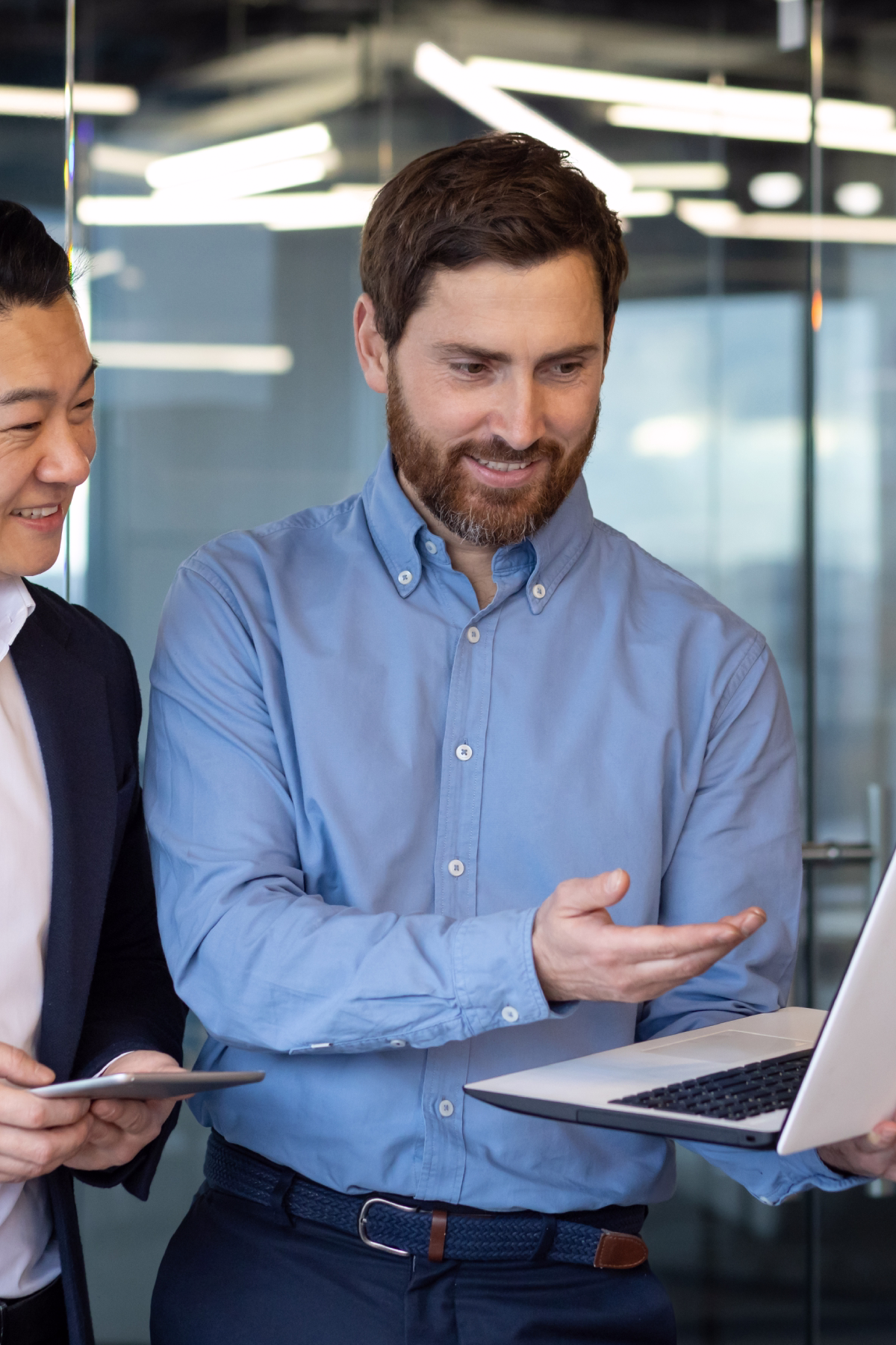 Two business professionals collaborating over a laptop in a modern office