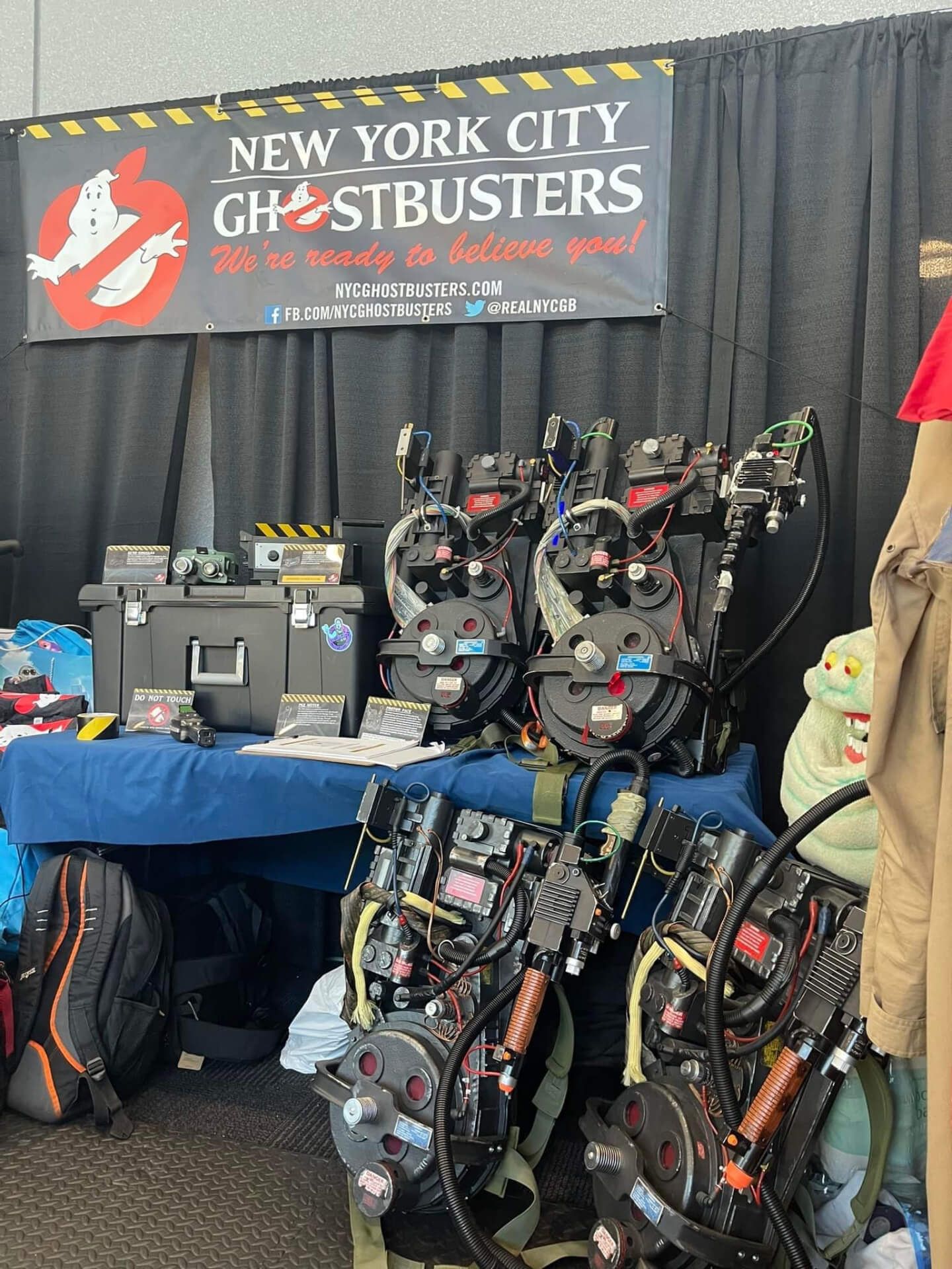 NYC Ghostbusters proton packs, Slimer puppet, and sign.