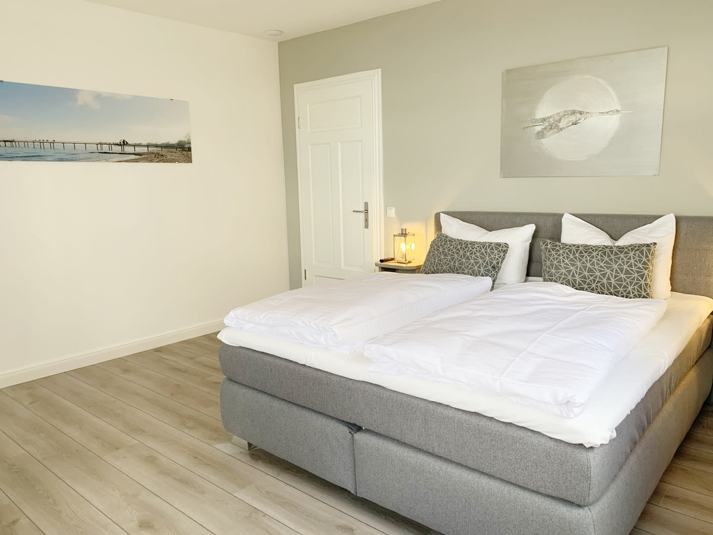 Schlafzimmer mit Doppelbett und Bildern and der Wand