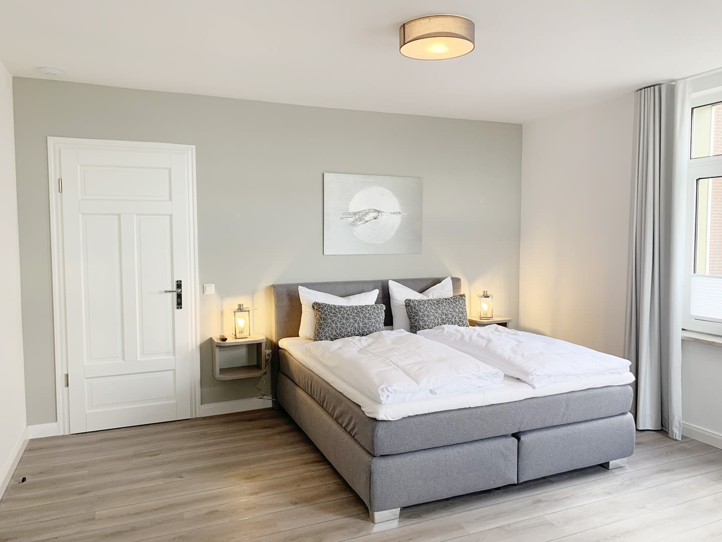 Schlafzimmer mit Doppelbett und Bild and der Wand