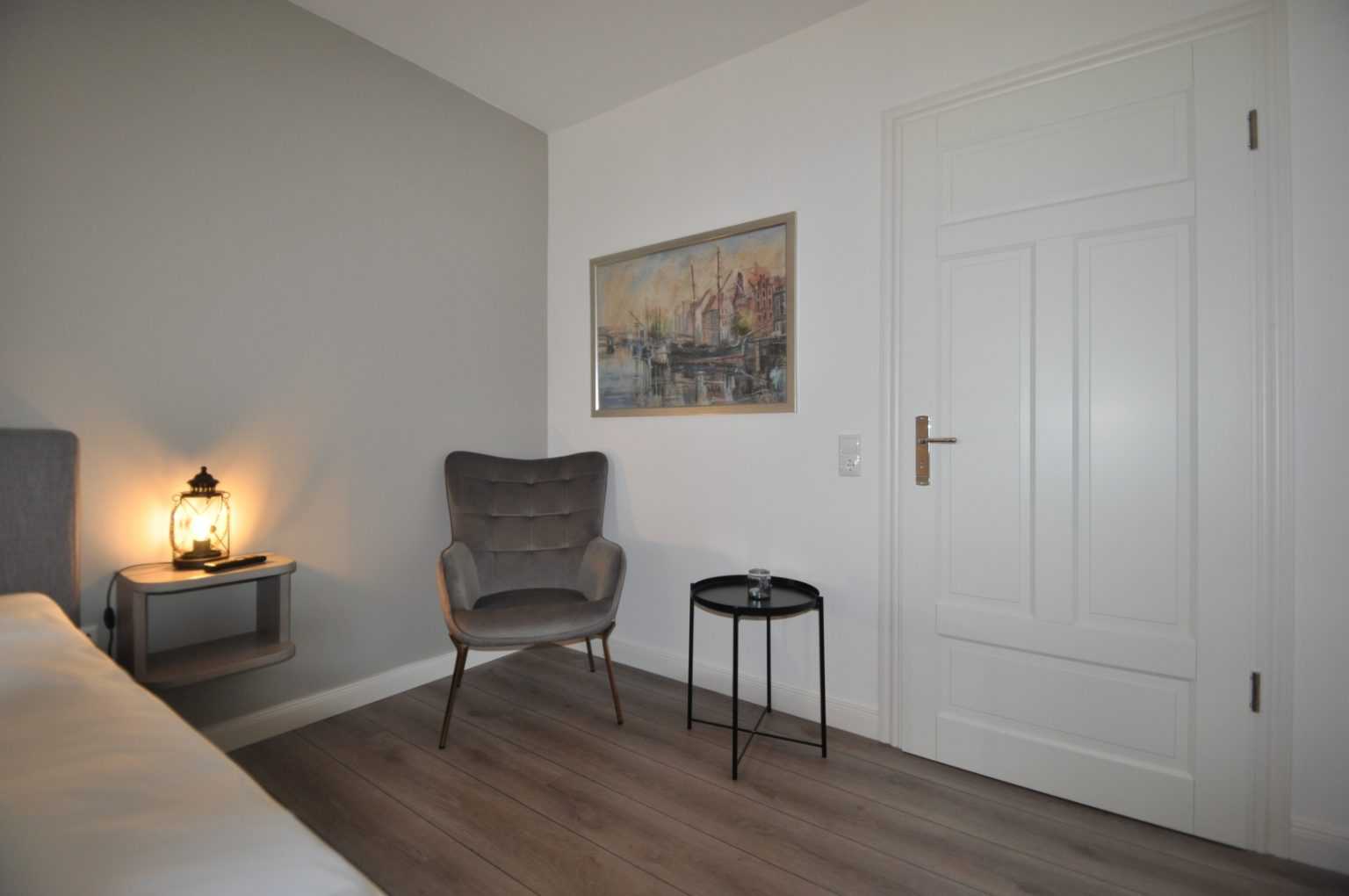 Sitzecke mit Sessel und Bild and der Wand