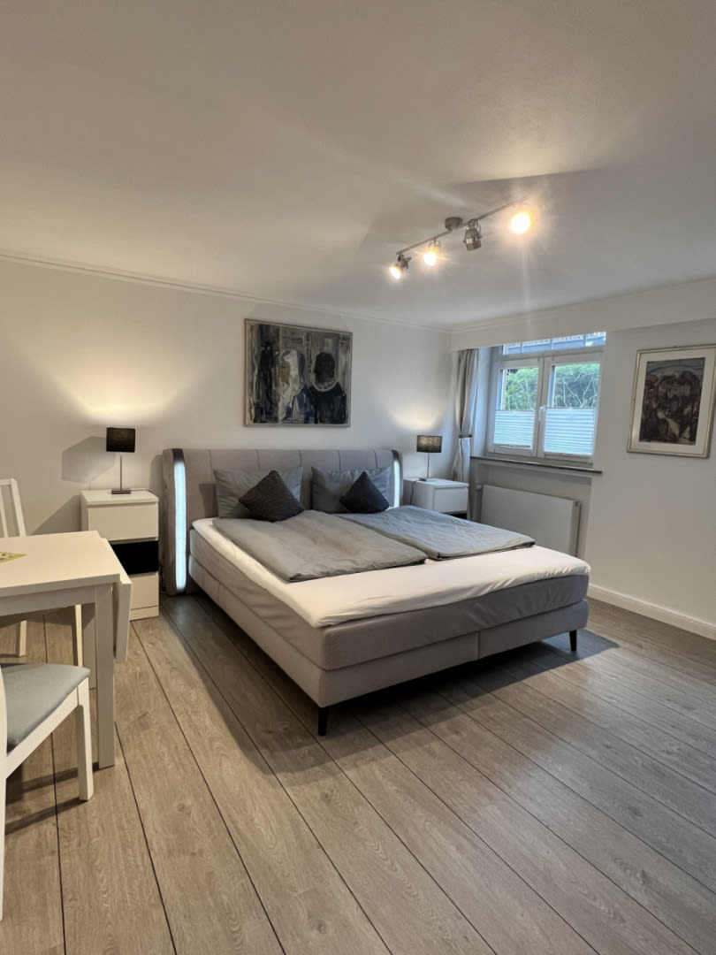 Schlafzimmer mit Doppelbett, Bilder an der Wand eine kleiner Tisch mit 2 Stühlen