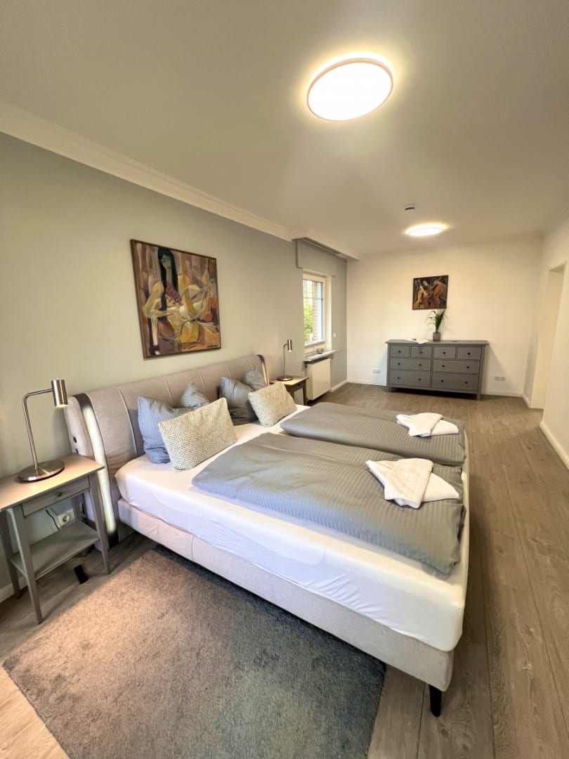 Schlafzimmer mit Doppelbett und Bild and der Wand