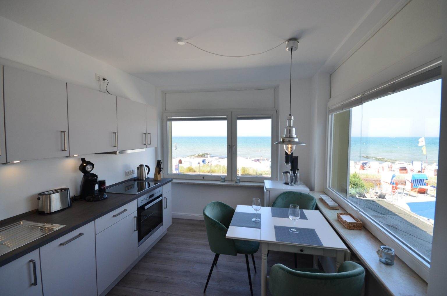Küche und Esszimmer mit Strandkörben und Ostsee im Hintergrund