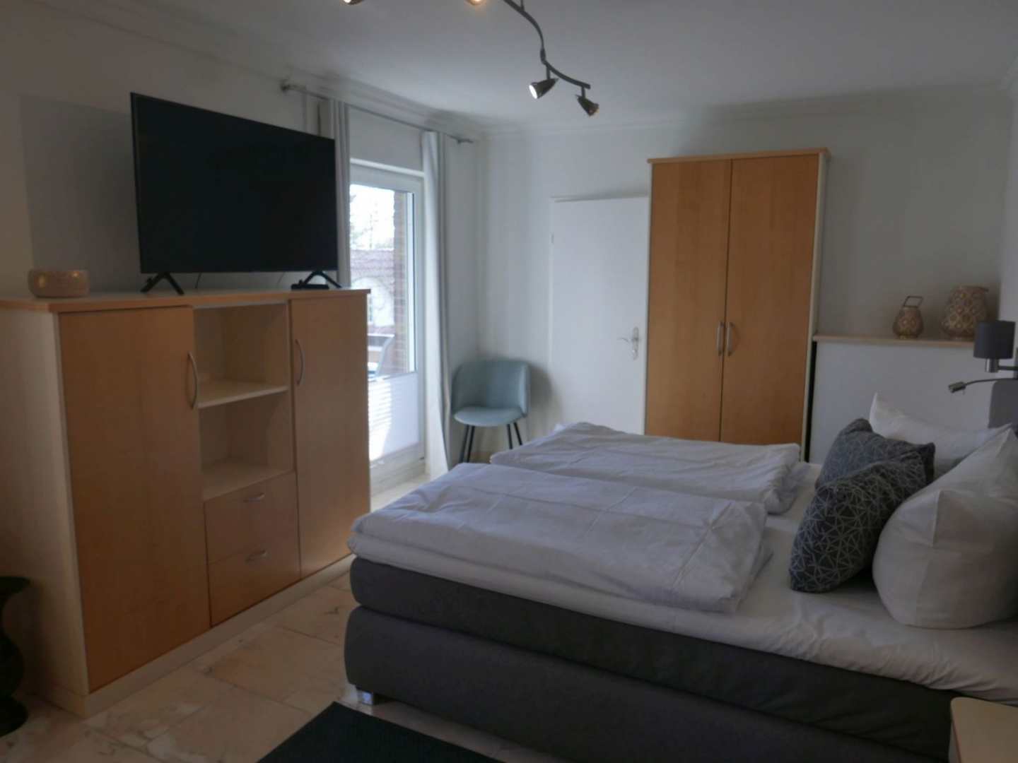 Schlafzimmer mit Fernseher und Kleiderschrank