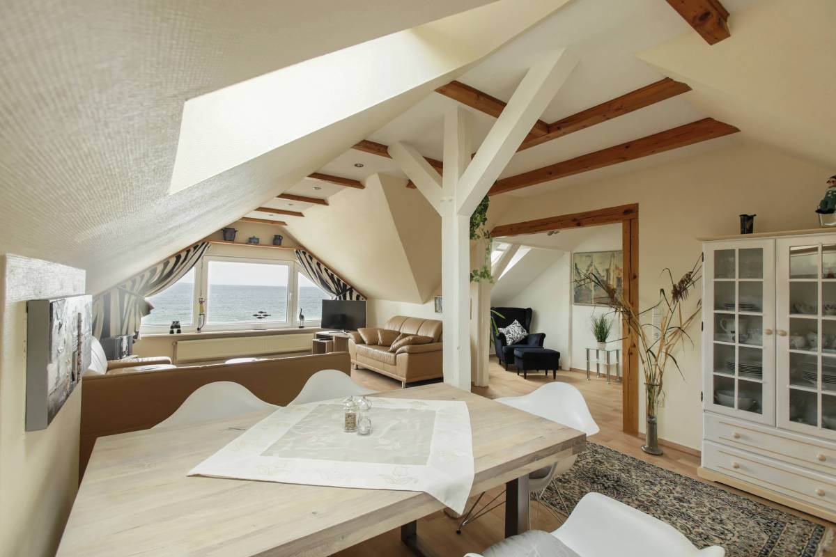 Esstisch mit Wohnzimmer und Meerblick im Hintergrund