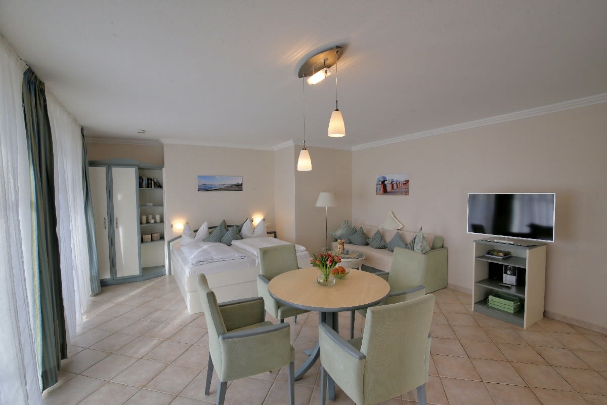 Wohn- und Schlafzimmer, Fernseher, Sofa, Doppelbett und Esstisch