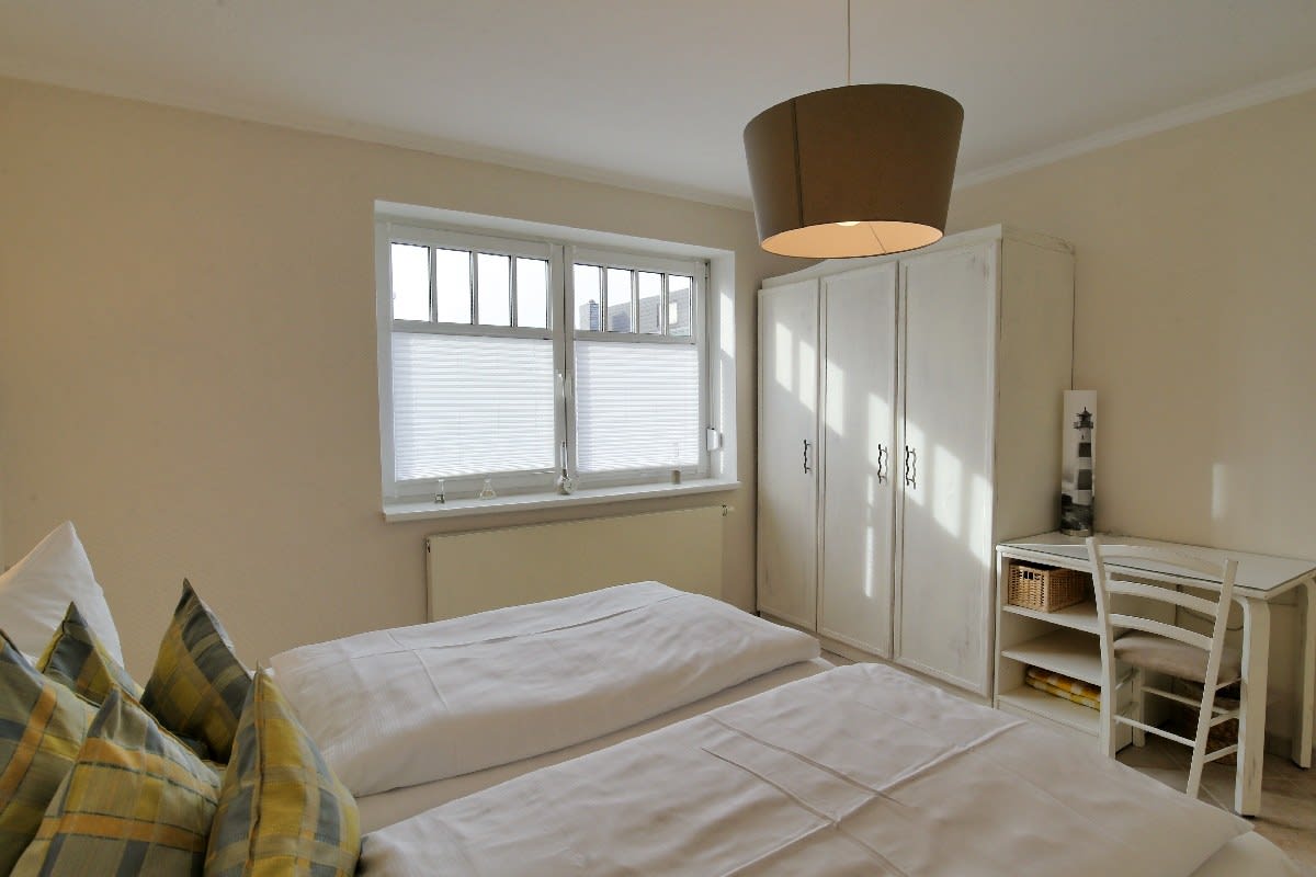 Schlafzimmer mit Kleiderschrank und kleinem Schreibtisch