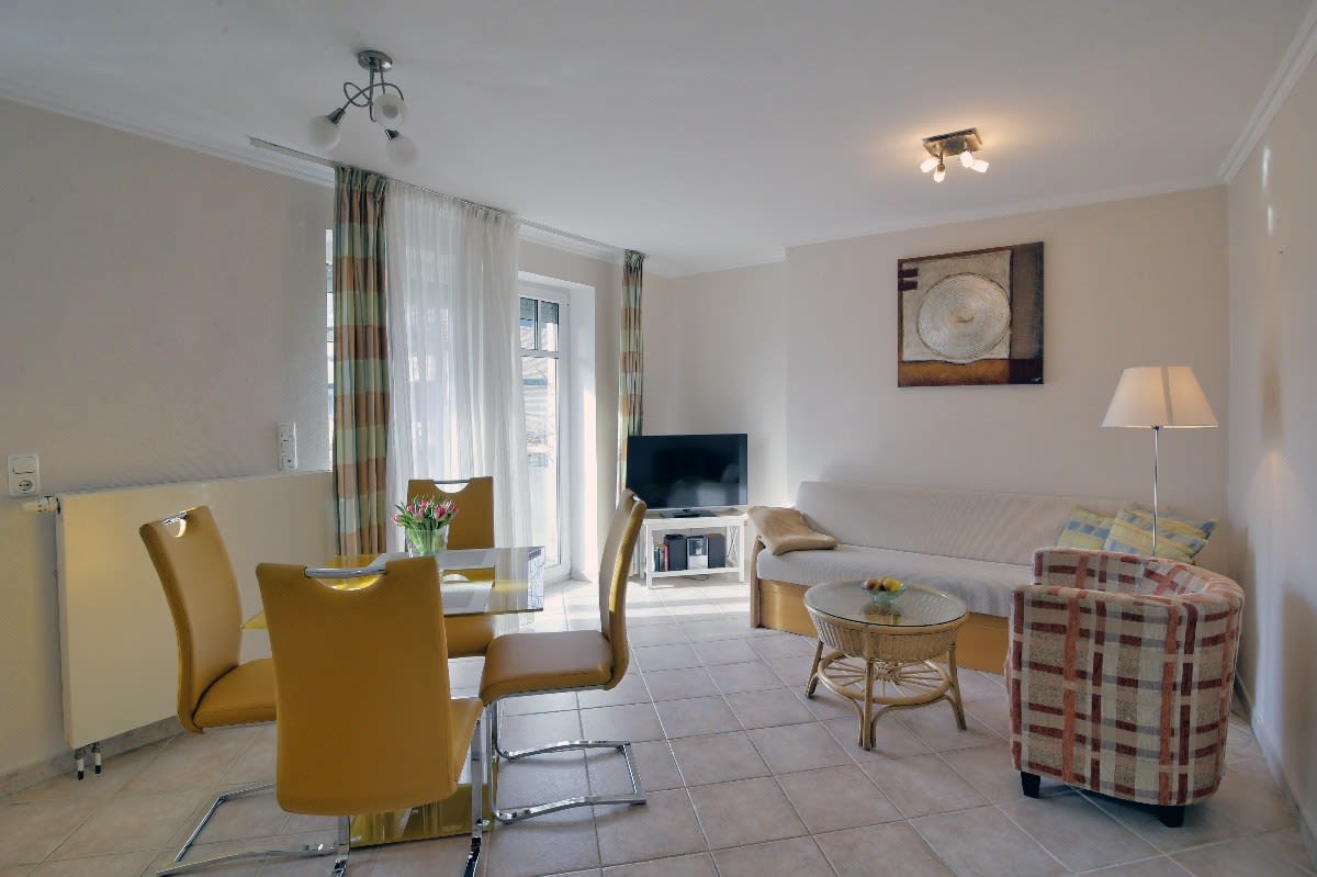 Wohnzimmer mit Esstisch, Couch und Fernseher