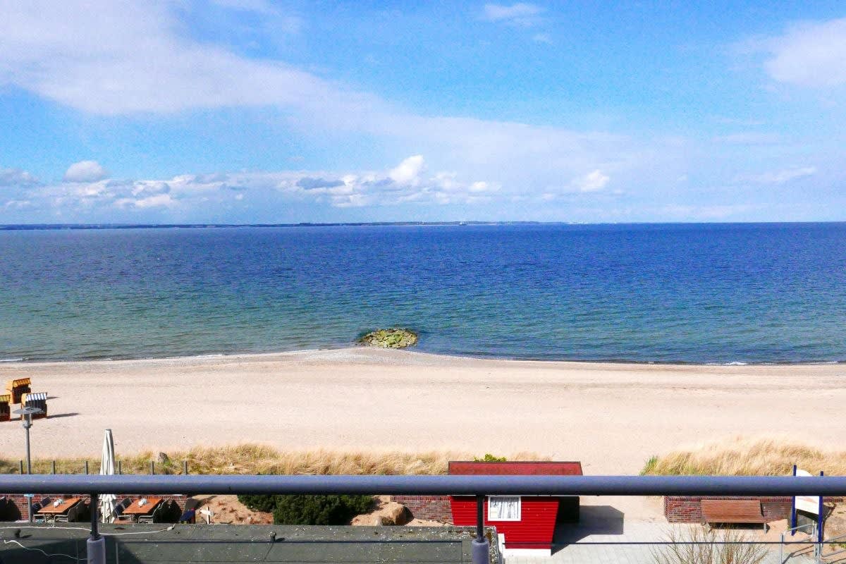 Ausblick vom Balkon. Der Strand ist leer, die Ostsee ist ruhig.