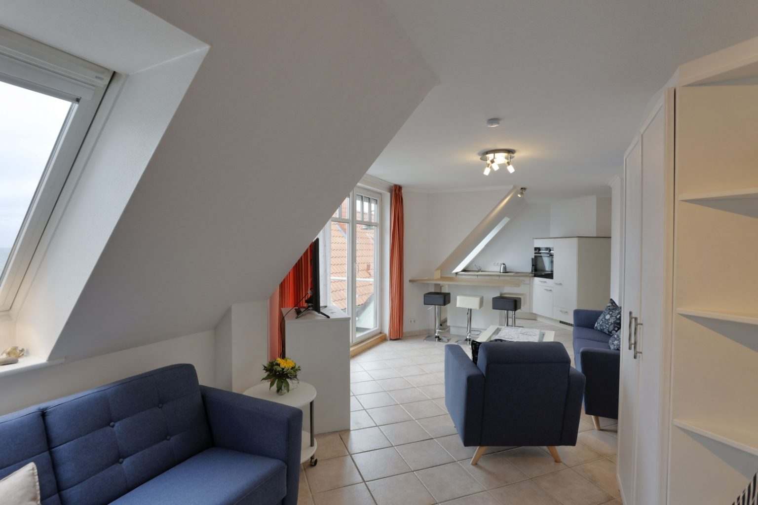 Blick auf das gesamte Wohnzimmer mit Küche im Hintergrund