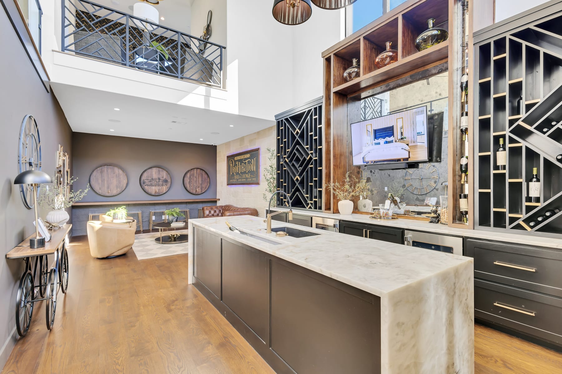 Two-story bar lounge with wine racks and waterfall marble island in an Allen, Texas estate