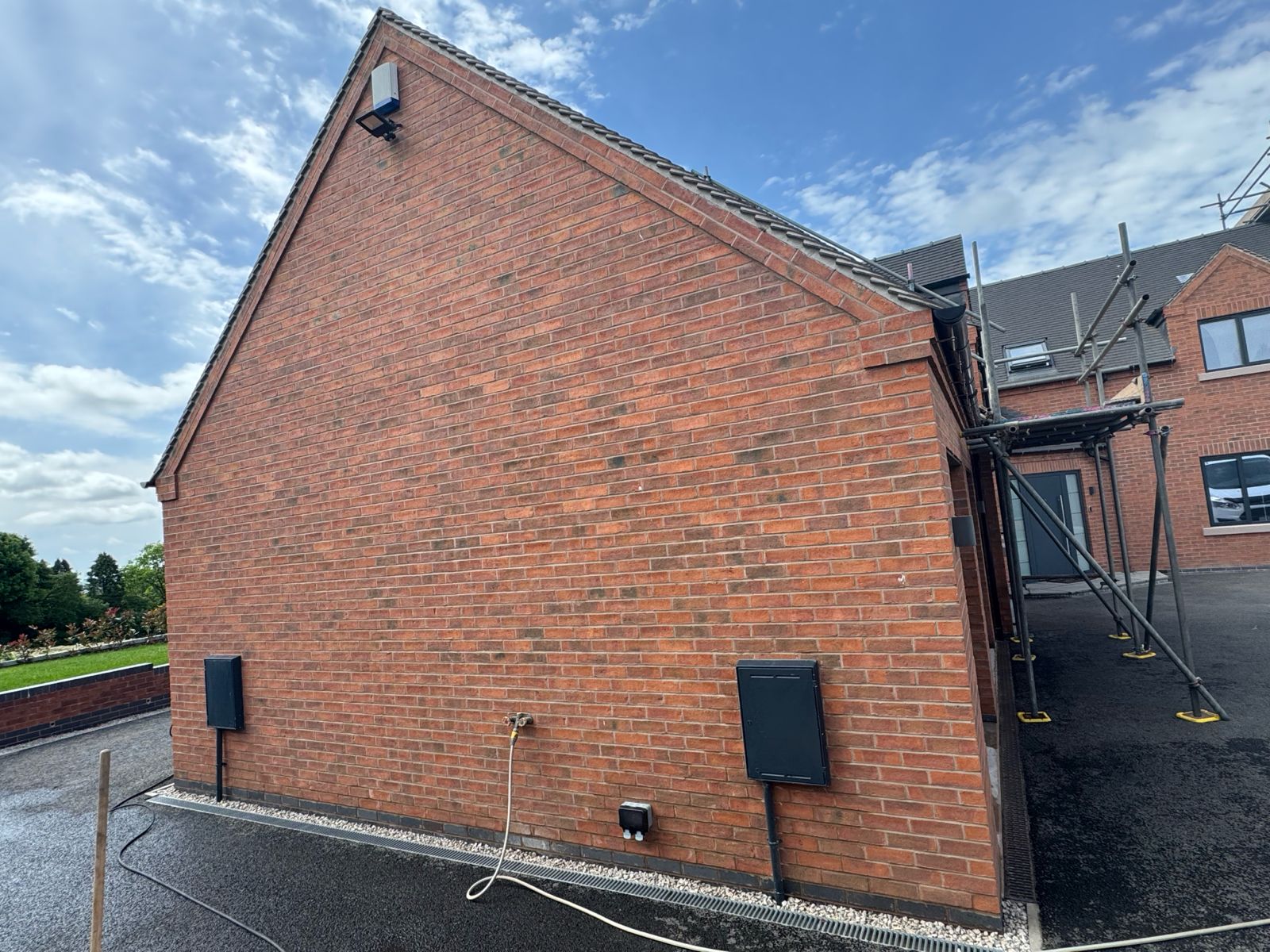 Side gable elevation — brickwork cleaning underway