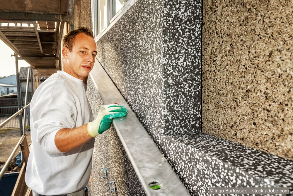 Homme isolant une façade depuis l'extérieur