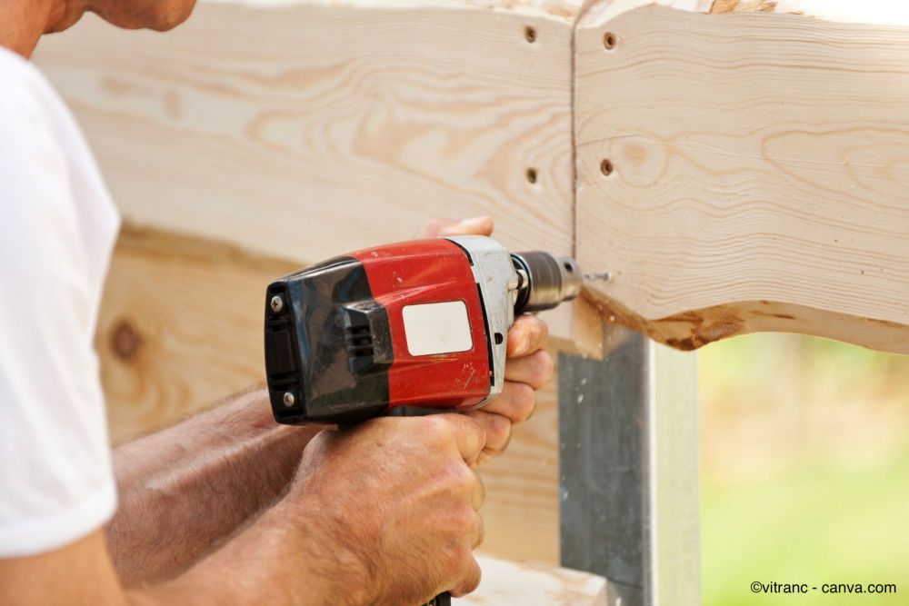 Utilisation d'une perceuse pour visser les vis dans les planches de la clôture en lattes
