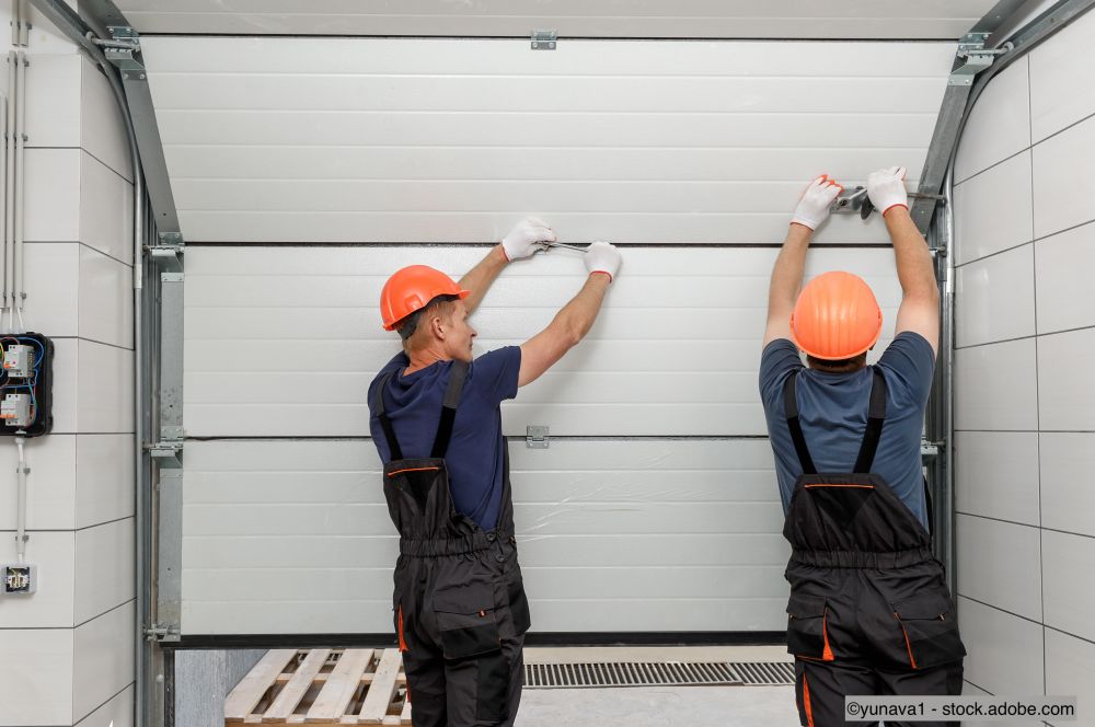 Handwerker bauen ein Sektionaltor ein