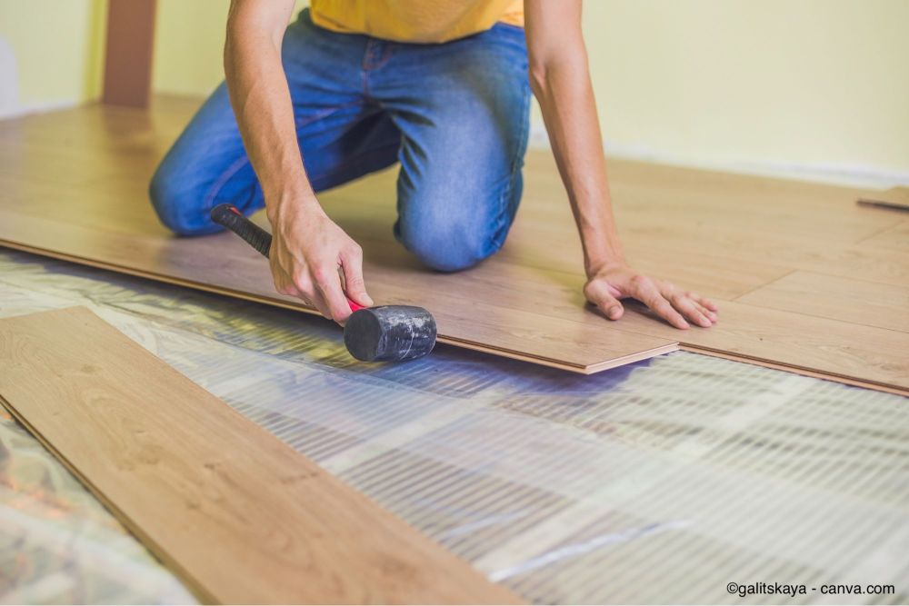 Homme posant un parquet à clipser