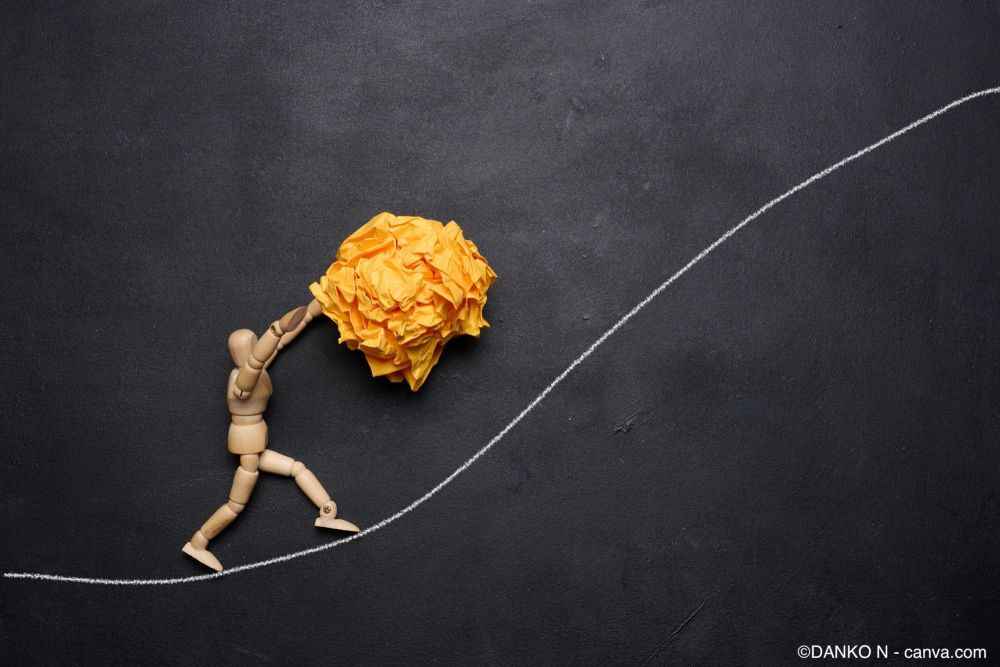 Holzfigur, die einen zerknüllten Papierball aufrollt