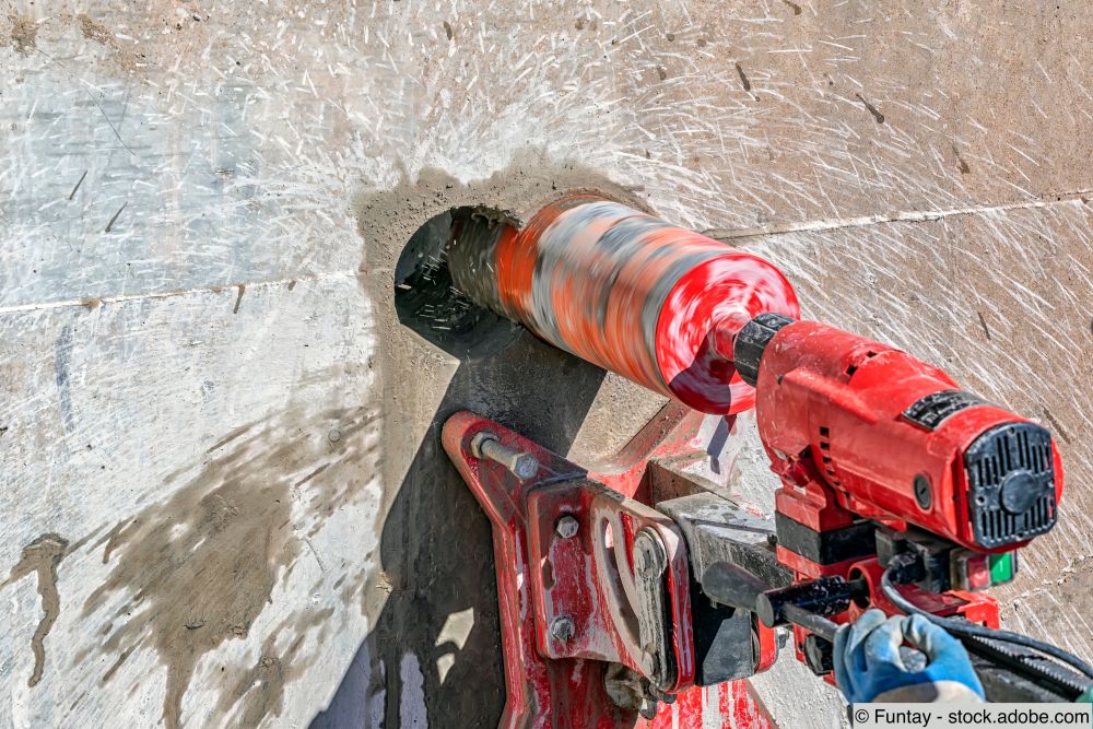 Fachmann bohrt mit einer Kernbohrmaschine in eine Betonwand
