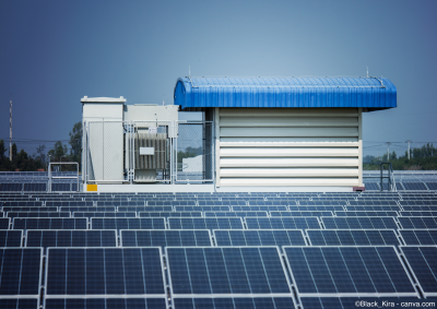 Cabine d'onduleurs photovoltaïques au milieu des modules solaires