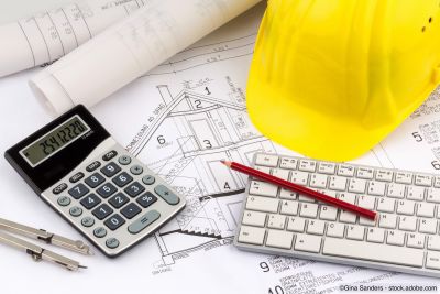 Maison et plan financier avec un casque de chantier.