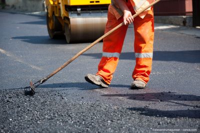 Un professionnel pose de l'asphalte frais sur une route