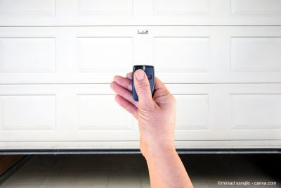 Un homme ouvre une porte de garage avec une télécommande