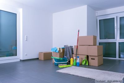 Appartement de luxe clair et vide avec des cartons et des produits de nettoyage sur un sol carrelé noir
