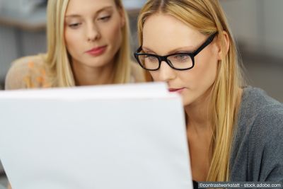 Zwei junge Frauen schauen konzentriert auf einen Entwurf