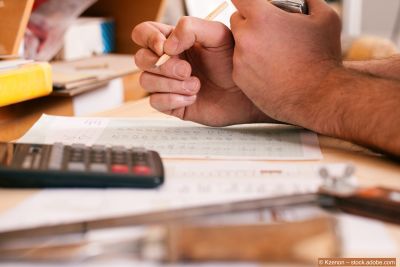 Mann-kalkuliert-eine-Offerte-mit-Taschenrechner