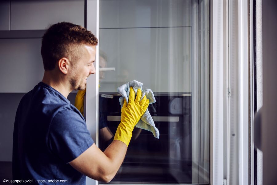Mann reinigt Fenster