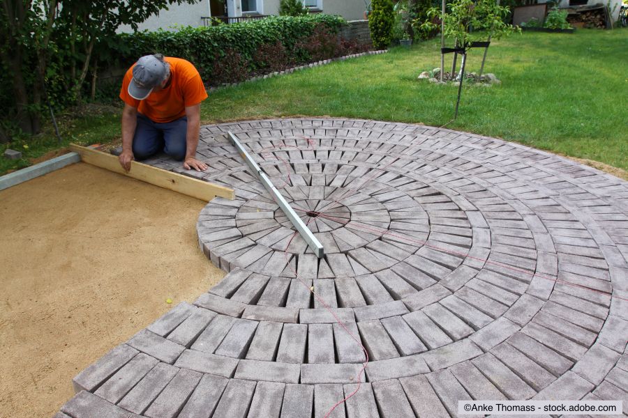 Handwerker verlegt Sickersteine für eine Terrasse