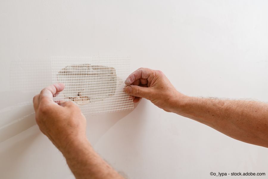 Ein Handwerker repariert ein Loch in der Trockenbauwand in der Wand